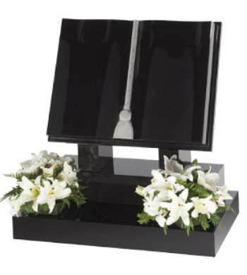 Black granite book shaped headstone with fully carved book, natural tassel on raised base.