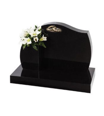 Black granite headstone with barrel sides and accompanying vase.
